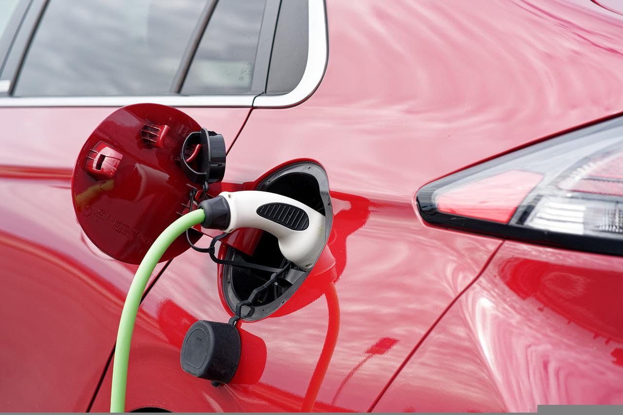 A red electric vehicle being charged