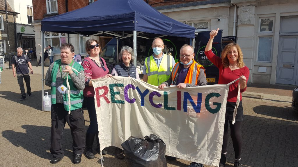 members of Stowmarket Eco Futures Group at an event holding up a banner saying "recycling"