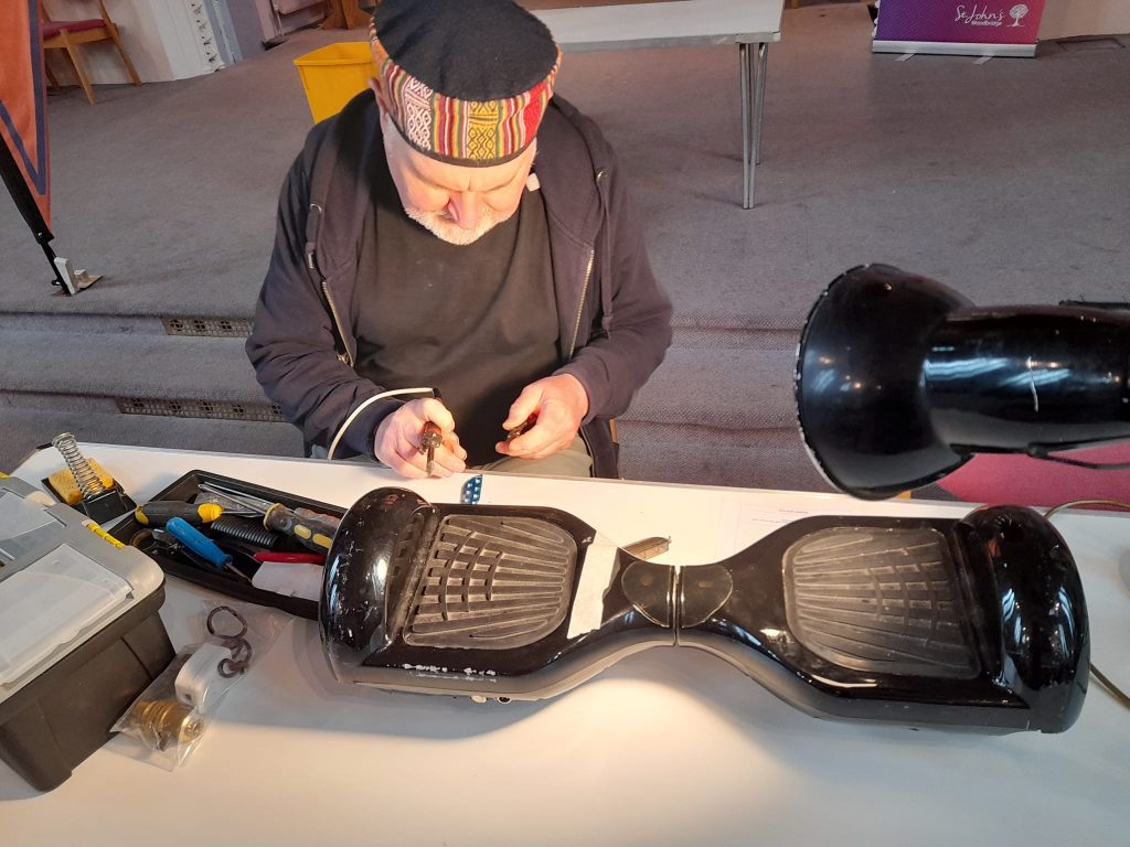 Someone repairing a hoverboard on a table